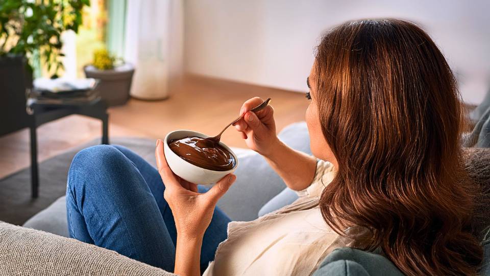 Donna che mangia un Budino proteico keto adatto alla dieta chetogenica della linea zero Glua