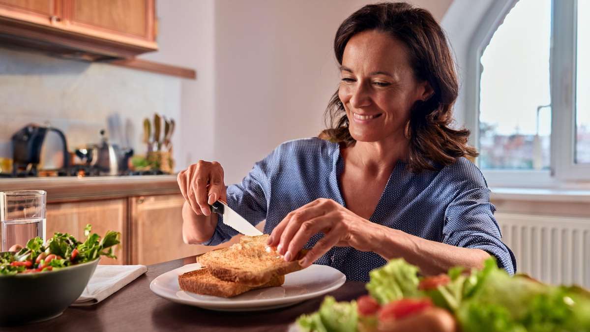 Donna che prepara un pranzo con il pane proteico Bauletto kegrano di glua per dieta chetogenica